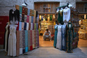 FILE - A vendor sits inside a shop at the empty Al Seef market, one of the main tourist areas of Dubai, United Arab Emirates, March 13, 2026, as tourism slows during the Iran war. (AP Photo/Fatima Shbair, File)