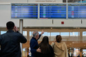 Travelers check departure times as many flights are cancelled at Beirut Rafik Hariri International Airport in Beirut, Lebanon, Saturday, Feb. 28, 2026, as many airlines canceled flights due to the conflict involving the United States, Israel and Iran. (AP Photo/Hassan Ammar)