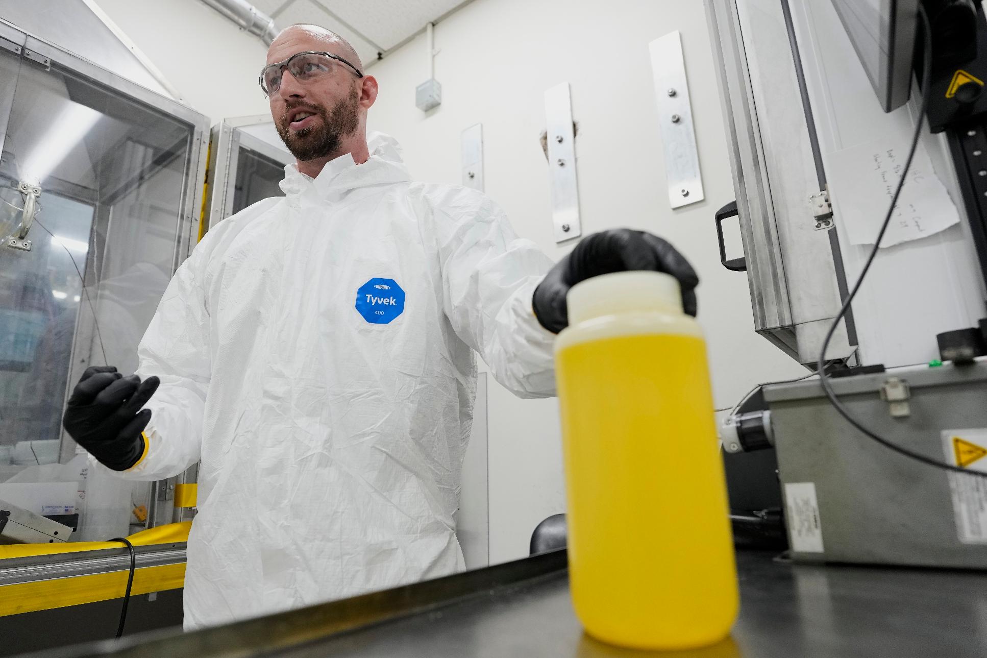 Dan Brown, vice president of fuel development for X-energy's subsidiary TRISO-X, demonstrates how liquid uranium is used to create TRISO fuel, Friday, June 27, 2025, in Oak Ridge, Tenn. (AP Photo/George Walker IV)