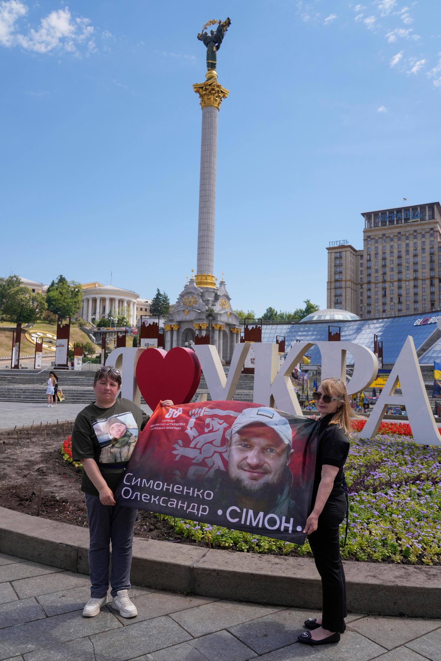 Women hold a banner with portrait of their relative during a rally of families of missing soldiers in Kyiv, Ukraine, Friday, May 22, 2026. (AP Photo/Efrem Lukatsky)