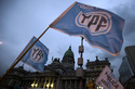 FILE - Supporters of an oil nationalization bill proposed by Argentina's President Cristina Fernandez wave flags that read in Spanish: "Fight and return YPF," outside Congress in Buenos Aires, Argentina, April 25, 2012. (AP Photo/Natacha Pisarenko, File)