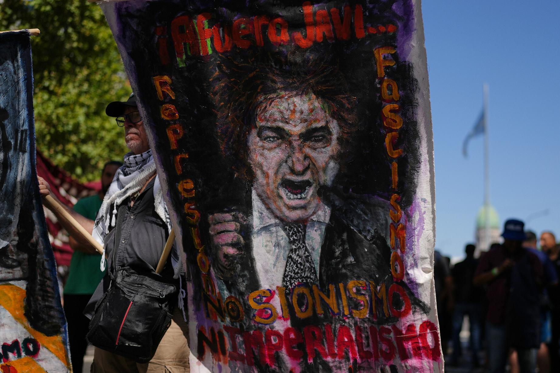 A protester holds a banner depicting Argentine President Javier Milei during a protest against a labor reform bill proposed by Milei's government in Buenos Aires, Argentina, Friday, Feb. 27, 2026. (AP Photo/Natacha Pisarenko)