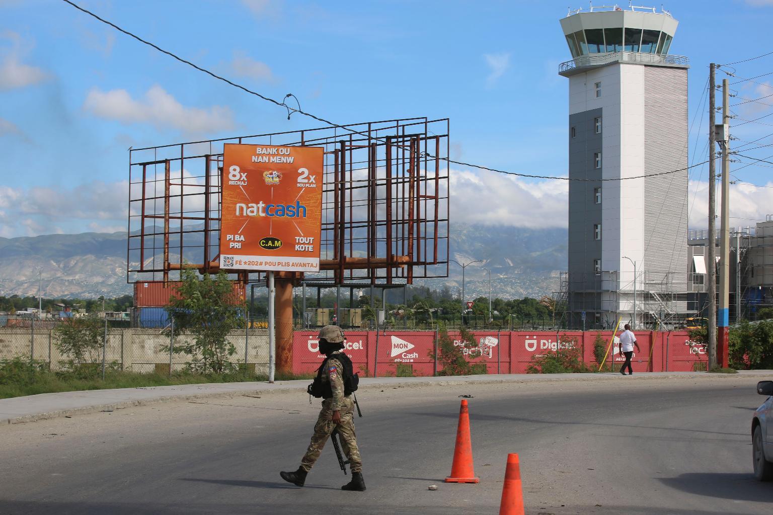 FILE - A police officer patrols the entrance of the Toussaint Louverture International Airport, in Port-au-Prince, Haiti, Nov. 12, 2024. (AP Photo/Odelyn Joseph, File)