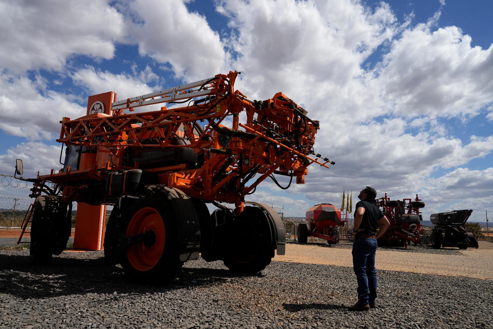 A salesman looks at agricultural machinery displayed at an equipment dealership, representing one of the sectors affected by U.S. tariffs, on the outskirts of Brasilia, Brazil, Wednesday, July 22, 2026. (AP Photo/Eraldo Peres)