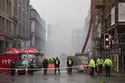 Firefighters damp down the remains of a fire which broke out in a building adjacent to Glasgow Central railway station on Sunday, in Glasgow, Scotland, Monday March 9, 2026. (Robert Perry/PA via AP)