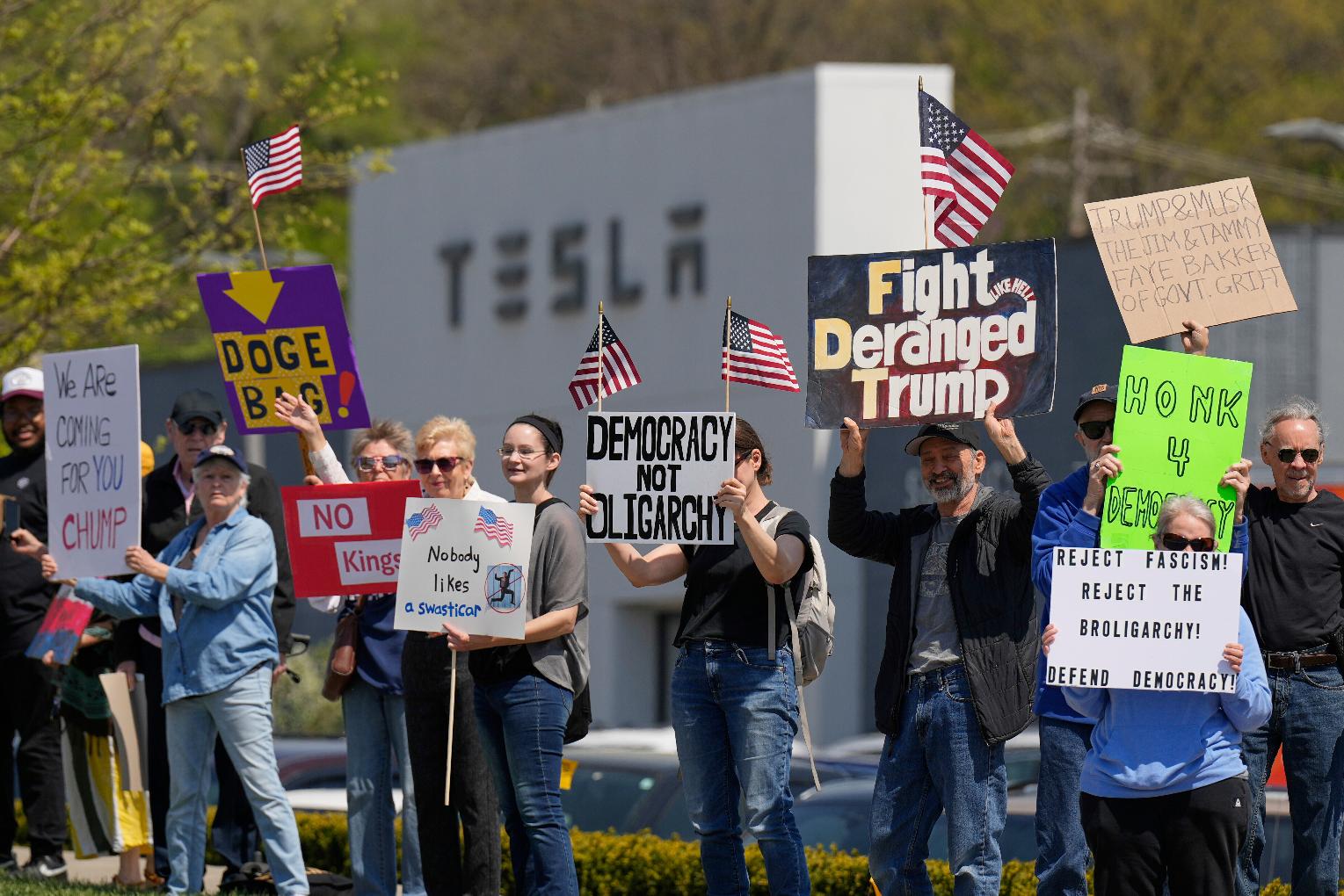 Demonstrators protest against Elon Musk and Department of Government Efficiency cuts outside a Tesla dealership, Saturday, April 12, 2025, in Kansas City, Mo. (AP Photo/Charlie Riedel)