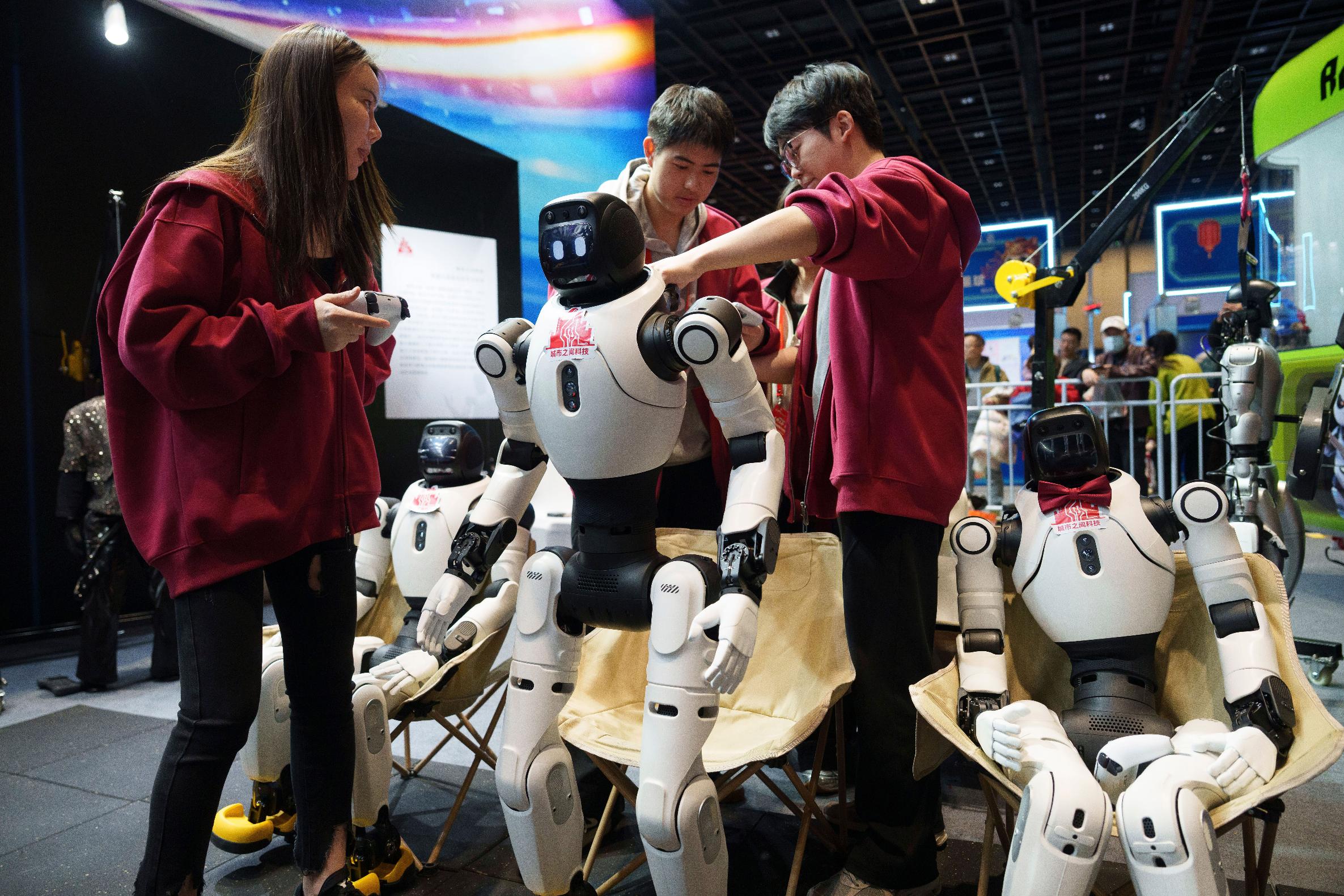 Workers prepare humanoid robots for a performance at a trade fair in Beijing, China, Wednesday, Feb. 18, 2026. (AP Photo/Vincent Thian)