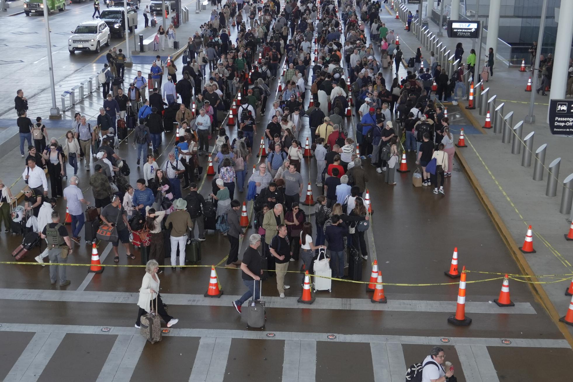 Travelers line up at a TSA checkpoint at George Bush Intercontinental Airport in Houston, Thursday, March 26, 2026. (AP Photo/Lekan Oyekanmi)