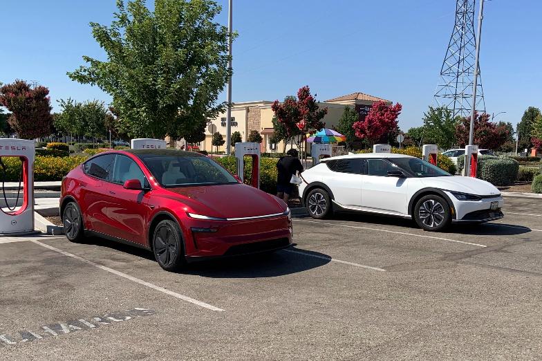 This photo provided by Edmunds shows a Tesla Model Y and a Kia EV6 parked at a Tesla Supercharger station in Fresno, Calif. Planning a cross-country trip in an EV takes extra effort, but doing it properly can make the journey almost as smooth as in a gas-powered vehicle. (Courtesy of Edmunds via AP)