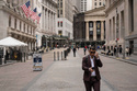 A person walks past the New York Stock Exchange, Friday, March 27, 2026, in New York. (AP Photo/Yuki Iwamura)