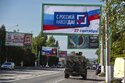 FILE - A military vehicle drives along a street with a billboard that reads: "With Russia forever, September 27", prior to a referendum in Luhansk, Luhansk People's Republic controlled by Russia-backed separatists, eastern Ukraine, Thursday, Sept. 22, 2022. Four occupied regions in Ukraine are set to start voting Friday Sept. 23, 2022 in Kremlin-engineered referendums on whether to become part of Russia, setting the stage for Moscow to annex the areas in a sharp escalation of the nearly seven-month war. (AP Photo/File)