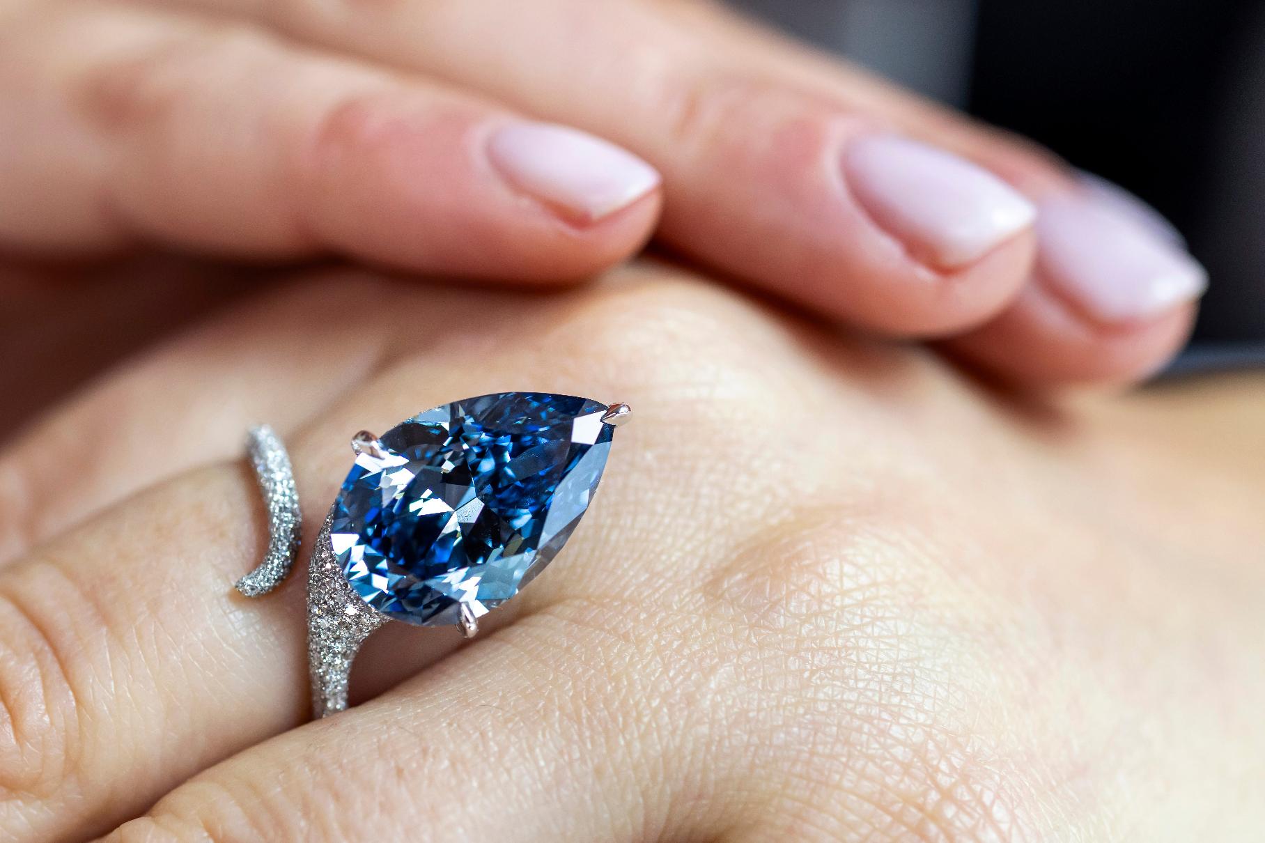 A Christie's employee displays the Mellon Blue, a fancy vivid blue pear-shaped diamond of 9.51 carats, during a preview at Christie's in Geneva, Switzerland, Friday, Nov. 7, 2025, ahead of an auction where it is estimated to sell for between 20 and 30 million US dollars. (Martial Trezzini/Keystone via AP)