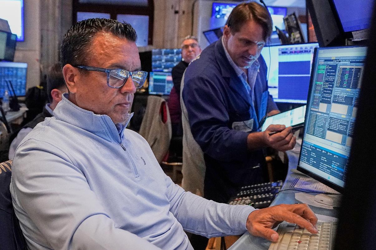 Traders Robert Finnerty Jr., left, and Michael Milano work on the floor of the New York Stock Exchange, Tuesday, July 29, 2025. (AP Photo/Richard Drew)