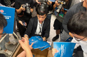 A man gives out copies of public consultation documents for Hong Kong's first five-year plan to reporters at the government headquarters in Admiralty district of Hong Kong, Monday, June 15, 2026. (AP Photo/Kanis Leung)