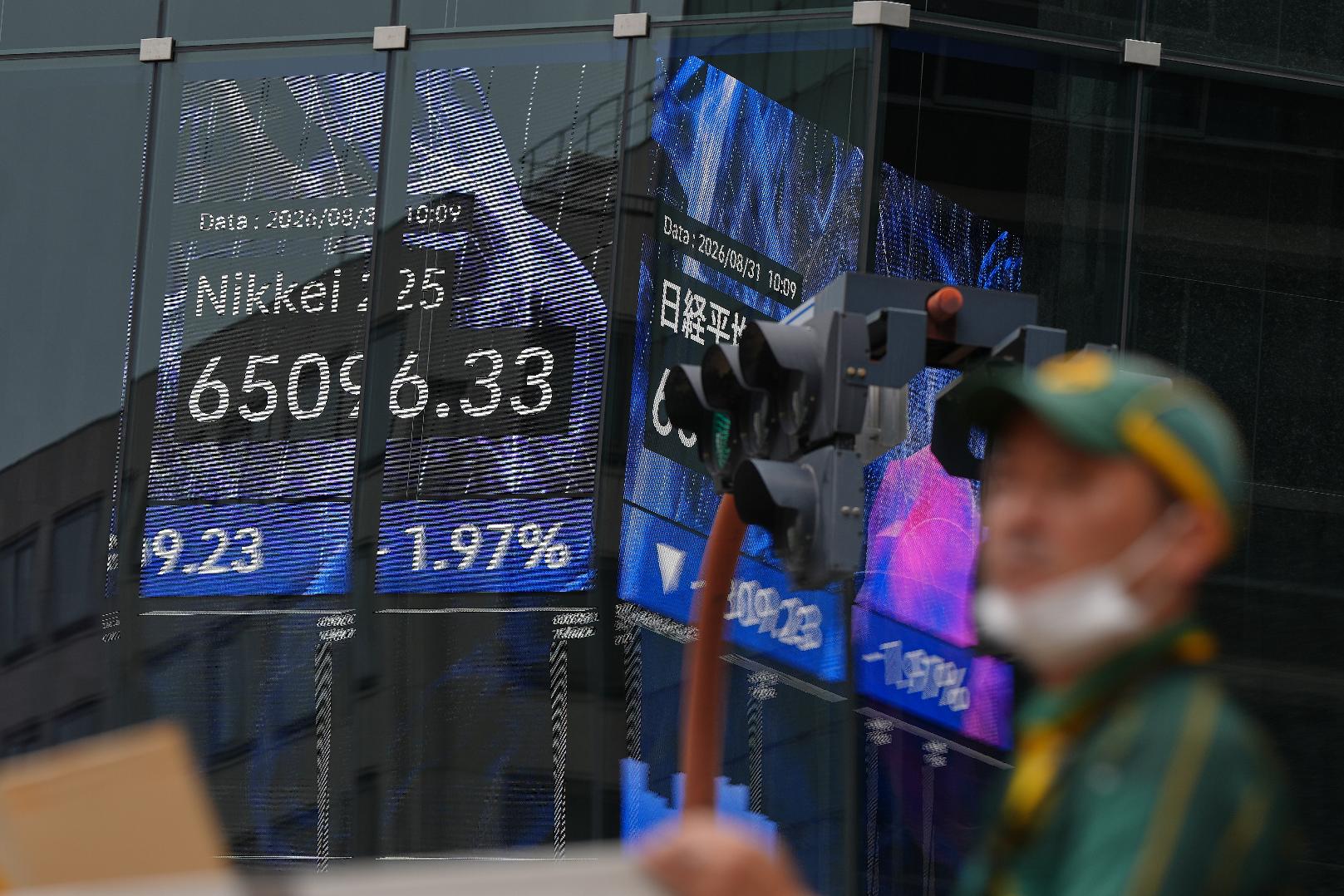 A person walks in front of an electronic stock board showing Japan's Nikkei index at a securities firm Monday, Aug. 31, 2026, in Tokyo. (AP Photo/Eugene Hoshiko)