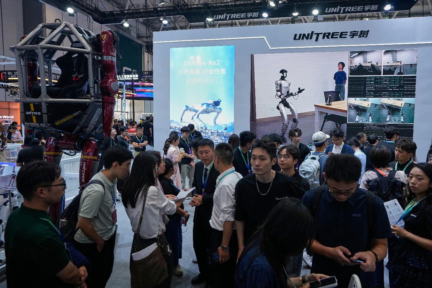 People visit a booth of Unitree, one of China's largest humanoid robot makers, during the World Robot Conference at the Beijing Yichuang International Convention and Exhibition Centre in Beijing, Wednesday, Aug. 19, 2026. (AP Photo/Andy Wong)