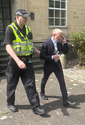 Co-founder of clothing firm Superdry James Holder, is escorted by a police officer as he leaves Cirencester Magistrates' Court, England, Friday, May 1 , 2026. (Rod Minchin/PA via AP)