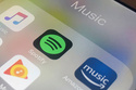 FILE - Music streaming apps, clockwise from top left, Apple, Spotify, Amazon and Google are displayed on an iPhone in New York, Jan. 28, 2018. (AP Photo/Jenny Kane, File)