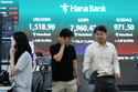 Currency traders pass by a screen showing the Korea Composite Stock Price Index (KOSPI) and the foreign exchange rate between U.S. dollar and South Korean won at the foreign exchange dealing room of the Hana Bank headquarters in Seoul, South Korea, Wednesday, June 10, 2026. (AP Photo/Ahn Young-joon)