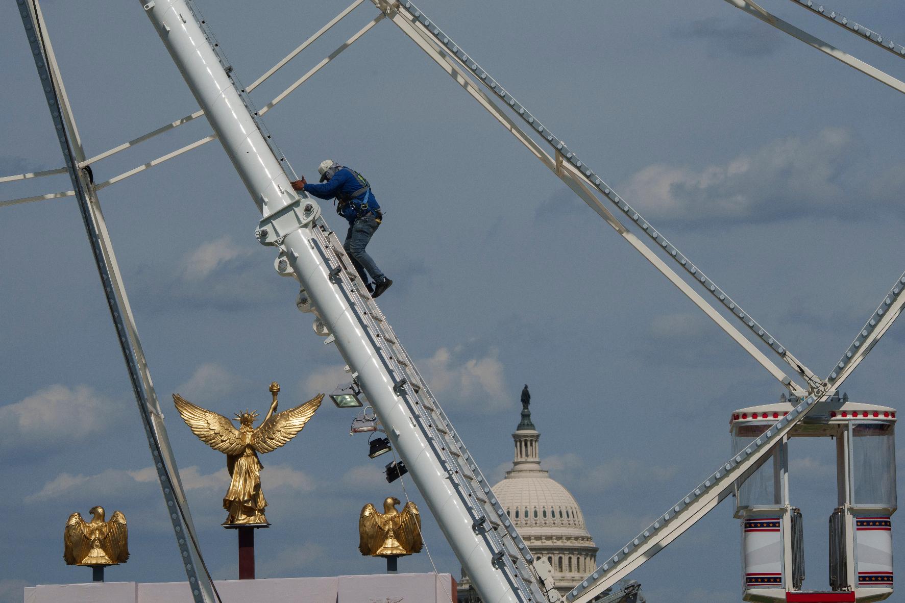 The U.S. Capitol is seen in the background of the ferris wheel as preparation continues for the Great American State Fair on the National Mall, Sunday, June 21, 2026, in Washington. (AP Photo/Jon Elswick