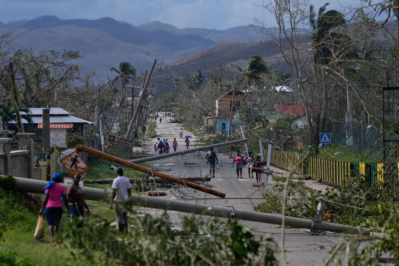 FILE - Residents walk through Lacovia Tombstone, Jamaica, in the aftermath of Hurricane Melissa, Wednesday, Oct. 29, 2025. (AP Photo/Matias Delacroix, File)