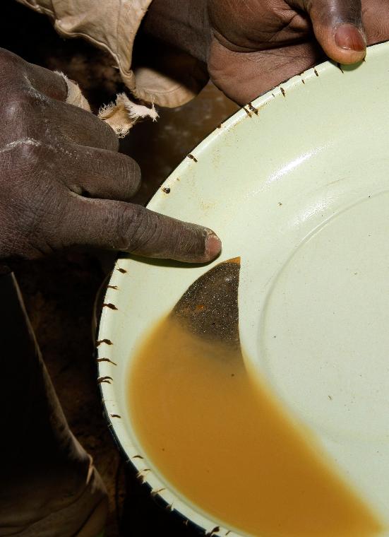FILE - Julius Mthembu points to the glimmering gold in an abandoned gold mine in Roodepoort, South Africa, Nov. 2, 2012. (AP Photo/Themba Hadebe, File)