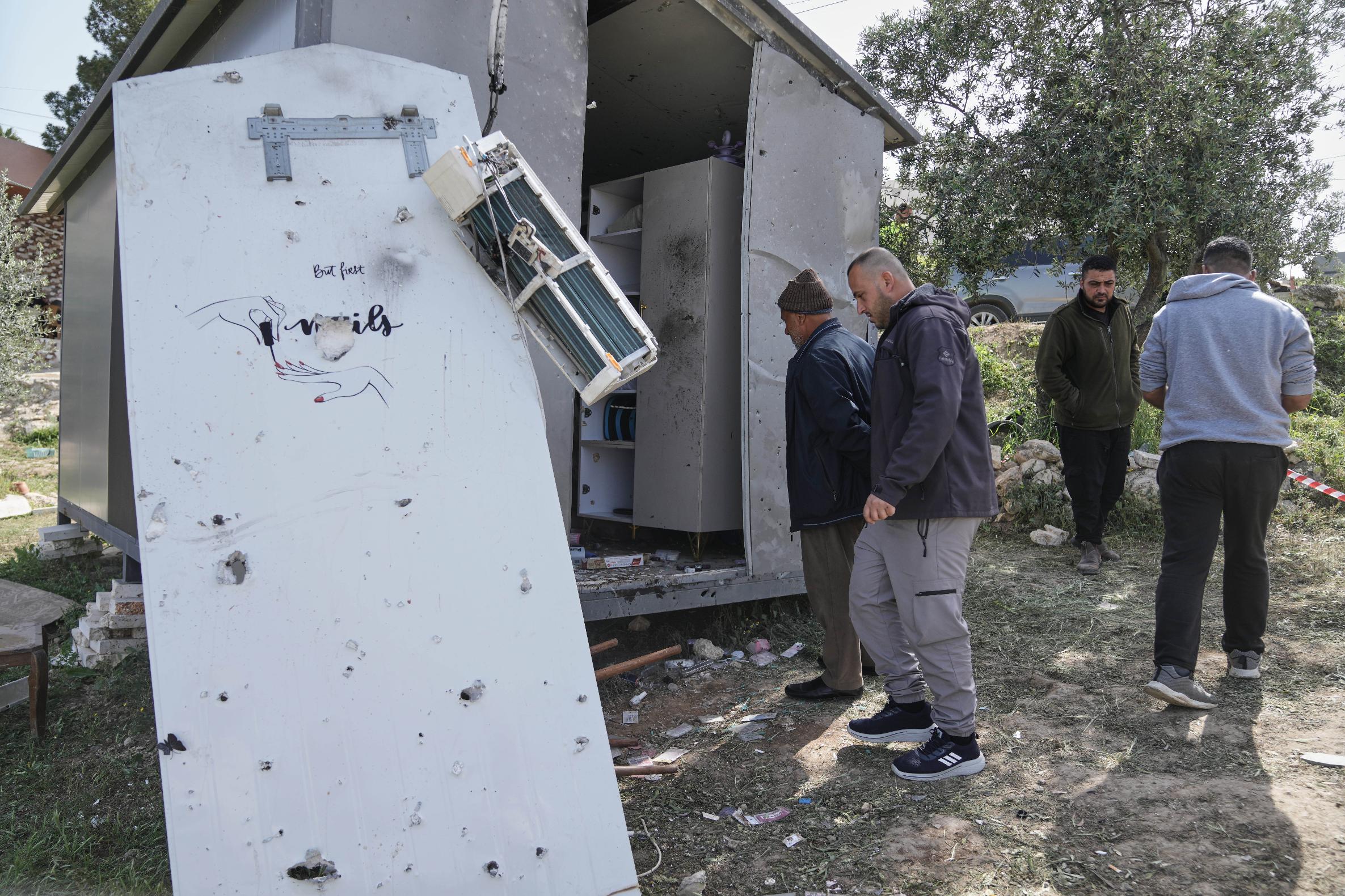 Palestinians inspect the damage at a beauty salon after a deadly Iranian strike in the West Bank village of Beit Awa, near Hebron, Thursday, March 19, 2026. (AP Photo/Mahmoud Illean)