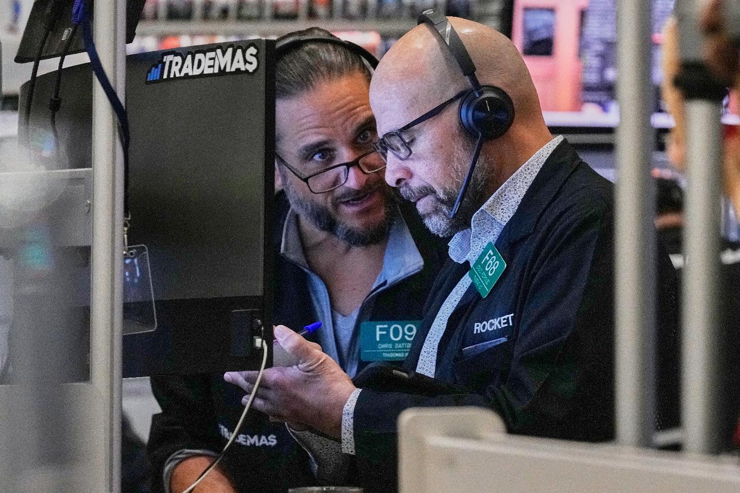 Options traders Chris Dattolo, left, and Steven Rodriguez work on the floor of the New York Stock Exchange, Friday, Feb. 20, 2026. (AP Photo/Richard Drew)