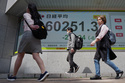 People past an electronic stock board showing Japan's Nikkei index at a securities firm Tuesday, April 28, 2026, in Tokyo. (AP Photo/Eugene Hoshiko)