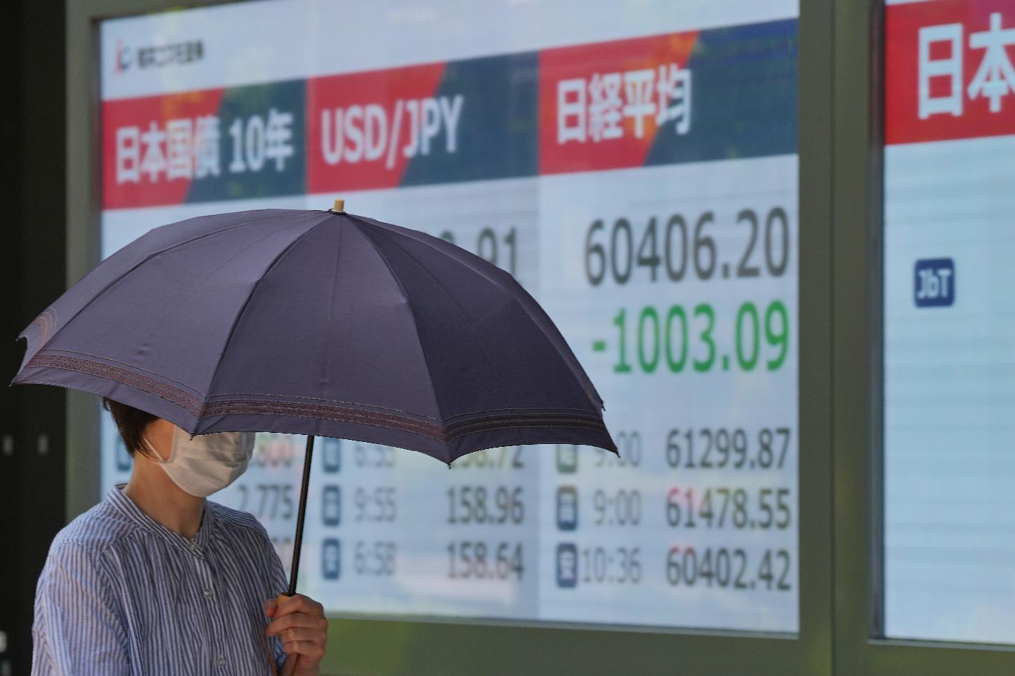A person walks in front of an electronic stock board showing Japan's Nikkei index at a securities firm Monday, May 18, 2026, in Tokyo. (AP Photo/Eugene Hoshiko)