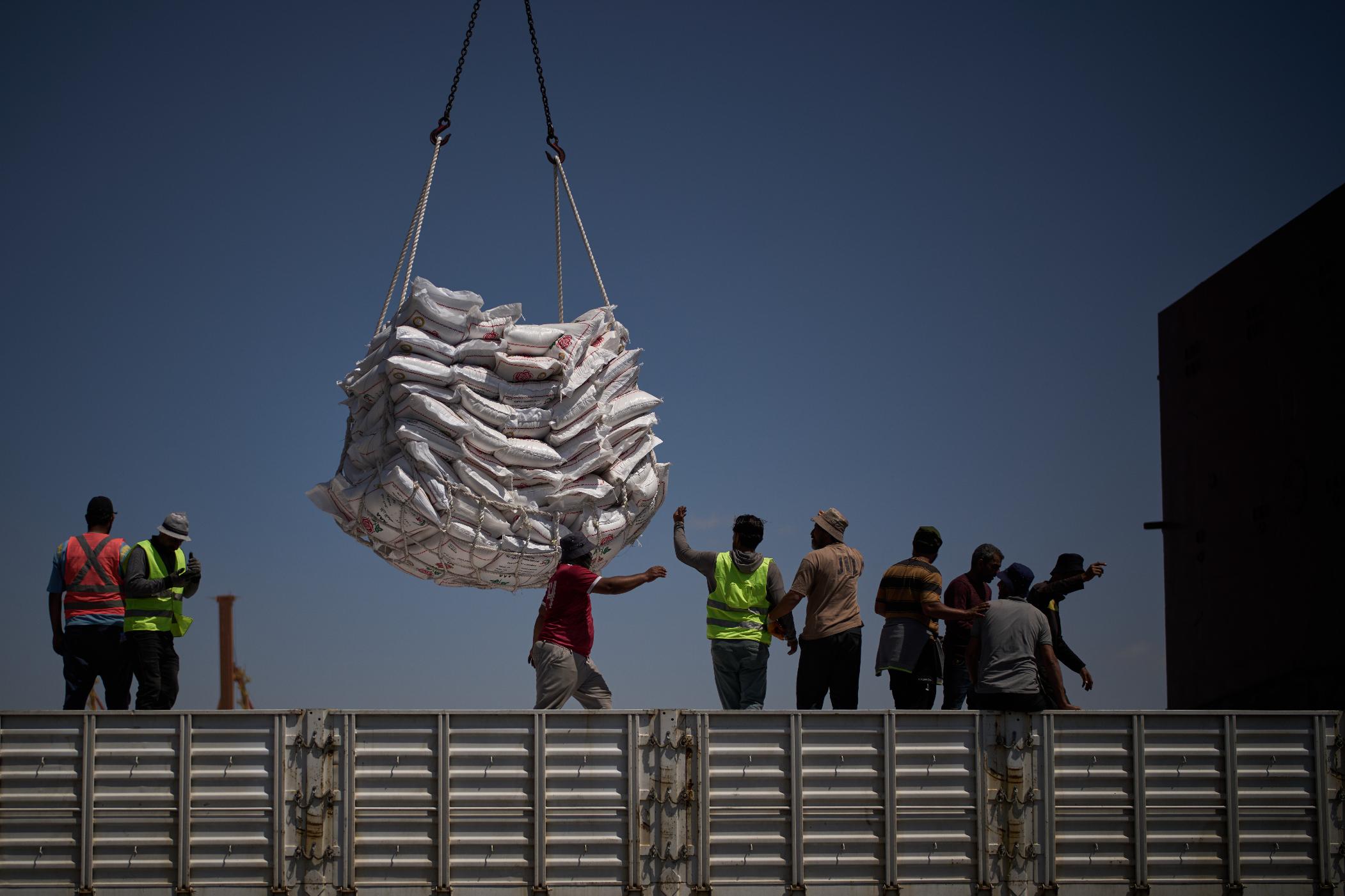 Workers offload cargo of rice from a feeder vessel into trucks at Umm Qasr Port, a deep-water port, in the city of Umm Qasr, Iraq, Friday, March 27, 2026. (AP Photo/Leo Correa)