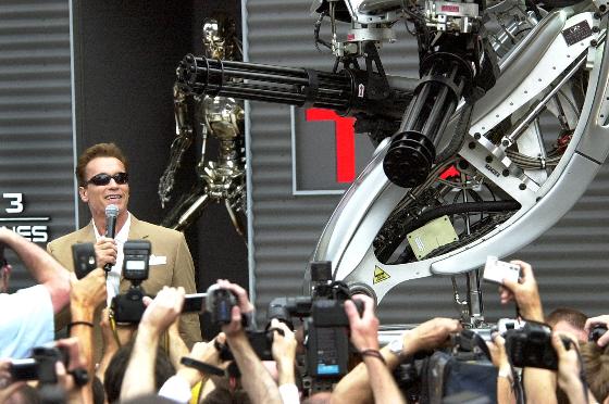 Arnold Schwarzenegger, poses next to a robot for the promotion of his new film "Terminator 3,"directed by American Jonathan Mostow, on the sideline of the 56th Film Festival in Cannes, France, Saturday, May 17, 2003. (AP Photo/Patrick Gardin)