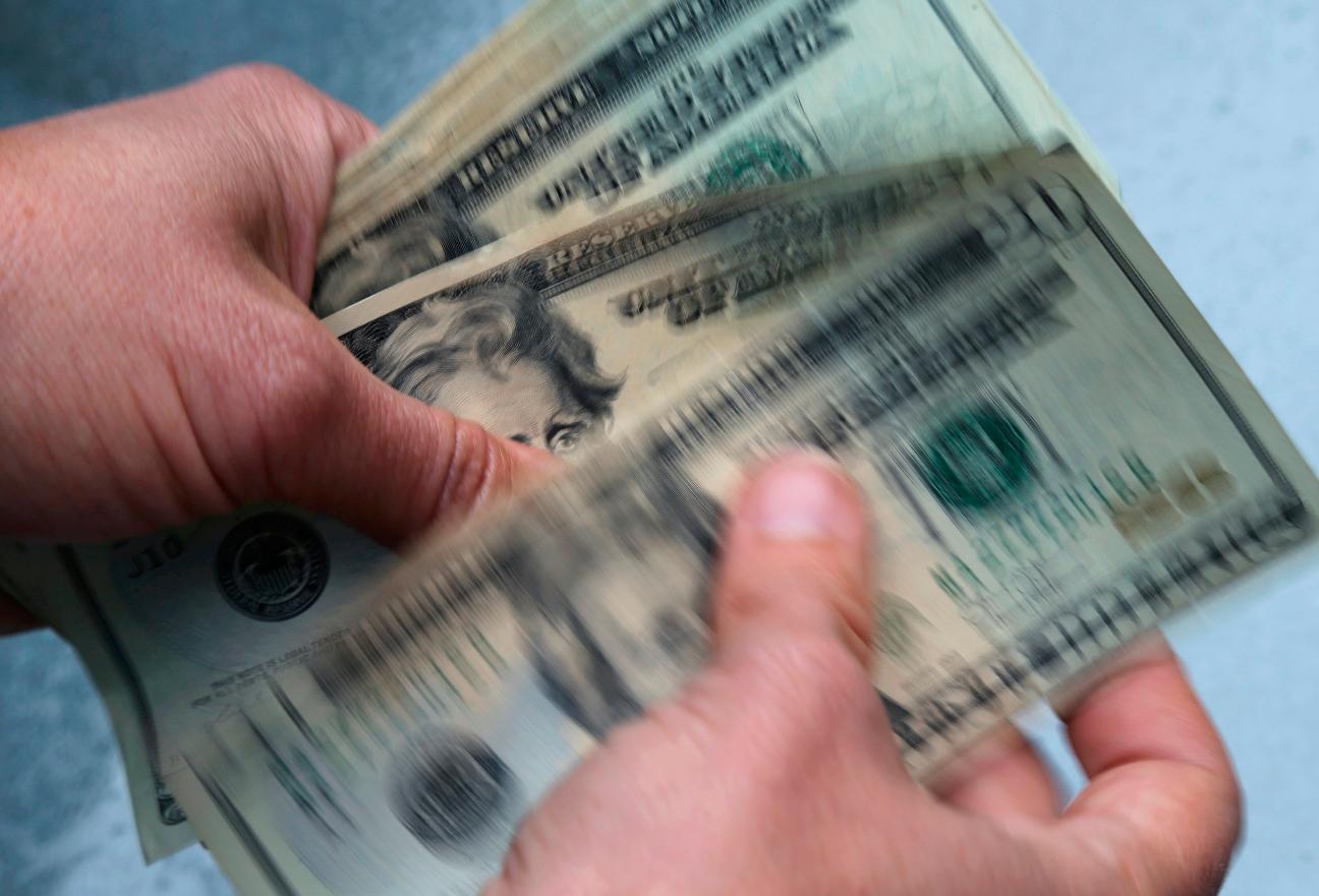 FILE- In this June 15, 2018, file photo, twenty dollar bills are counted in North Andover, Mass. (AP Photo/Elise Amendola, File)