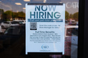 A now hiring sign sits on the window of a retail clothing store in Garland, Texas, Monday, March 23, 2026. (AP Photo/LM Otero)