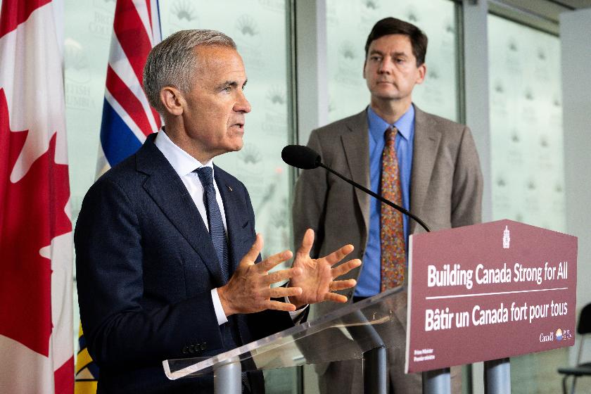 Prime Minister Mark Carney speaks accompanied by British Columbia Premier David Eby, right, in Vancouver, on Thursday, July 2, 2026. (Ethan Cairns/The Canadian Press via AP)