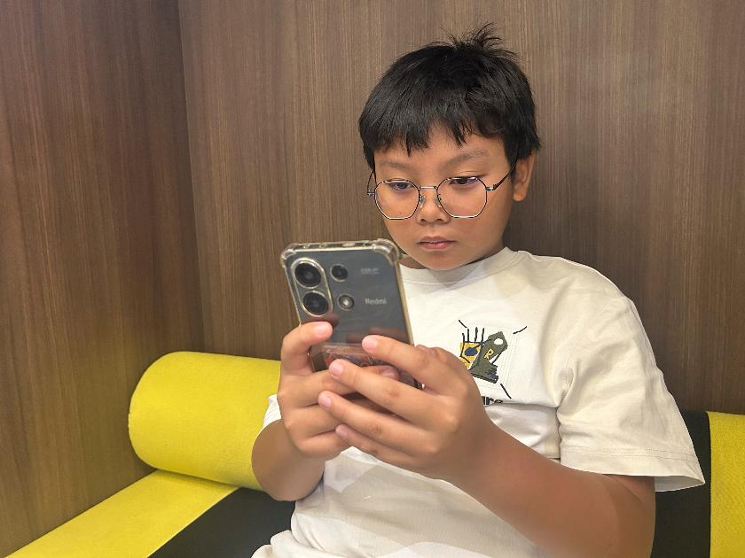 Hew Chee Weng, 11, uses a smartphone in Kuala Lumpur, Malaysia, Monday, June 1, 2026. (AP Photo/Syawalludin Zain)