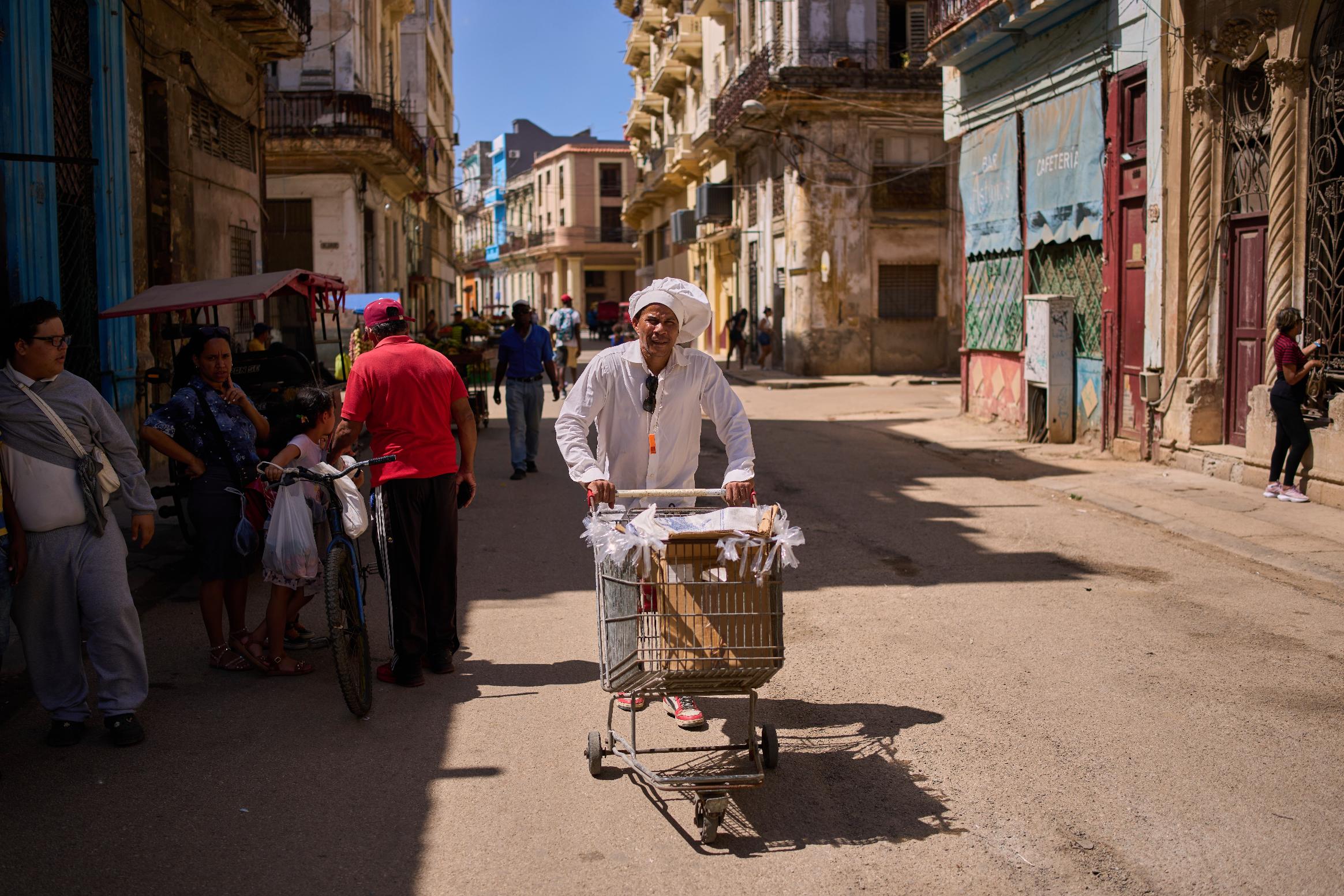 A baker hawks his baked goods through the streets of Havana, Cuba, Thursday, March 5, 2026, during a blackout. (AP Photo/Ramon Espinosa)