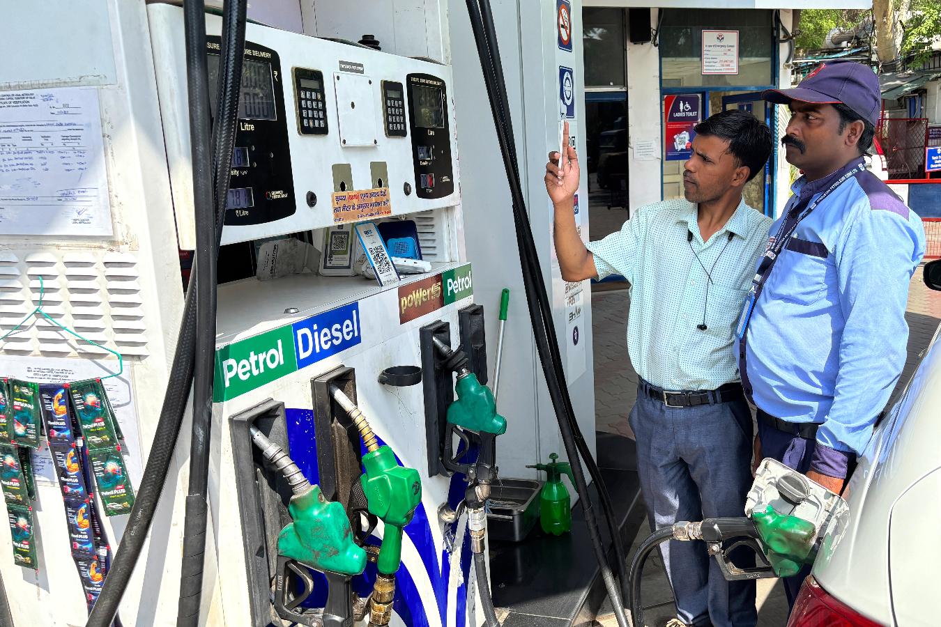 A commuter monitors the meter as an attendant refuels his vehicle at a filling station in New Delhi, India, Friday, May 15, 2026. (AP Photo/Shonal Ganguly)