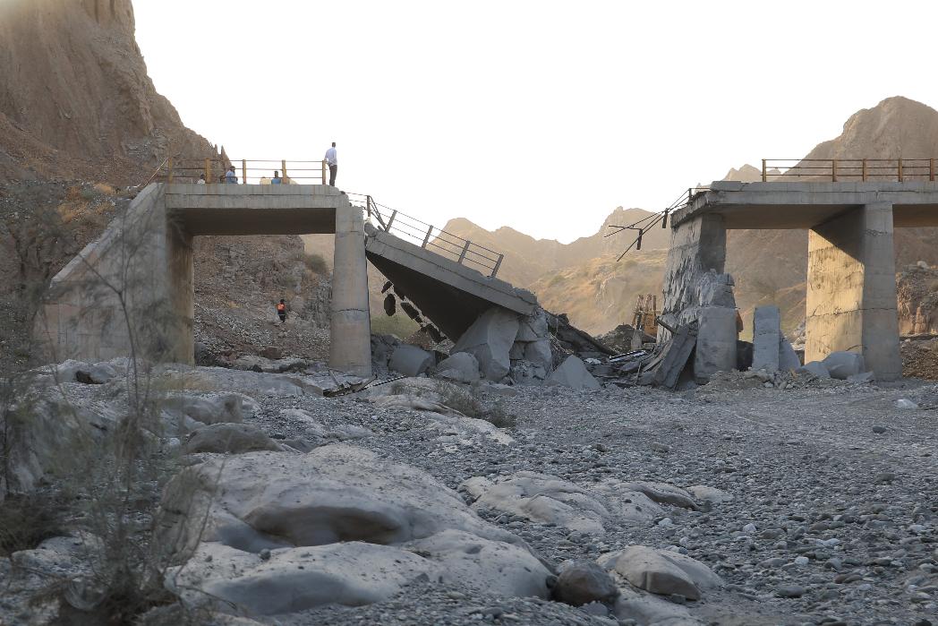 People stand on a bridge destroyed after a strike in Hormozgan province, southern Iran, Saturday, July 18, 2026. (Amirhosein Khorgooi/Iranian Students' News Agency via AP)