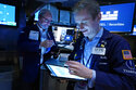 Traders David O'Day, left, and Colby Nelson work on the floor of the New York Stock Exchange, Wednesday, Dec. 1, 2021. The latest move in Wall Street's jolting roller-coaster ride is back up, as stocks, oil and bond yields climb in early Wednesday trading to recover some of their sharp losses from the day before. (AP Photo/Richard Drew)