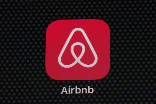 FILE - The Airbnb app icon is seen on an iPad screen, Saturday, May 8, 2021, in Washington.  Airbnb will allow its employees to live and work almost anywhere around the world, fully embracing a remote work policy to attract staff and ensure flexibility.  The San Francisco short-term-stay company said late Thursday, April 28, 2022,  that under the new policy, employees can work from the office, home or during their travels to 170 countries. (AP Photo/Patrick Semansky, File)
