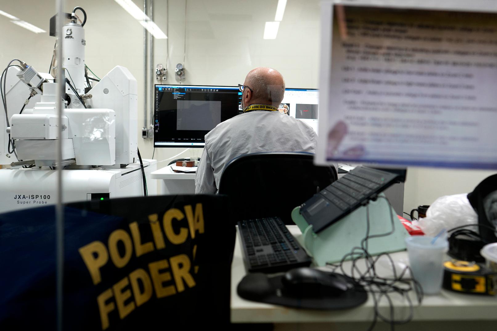 A federal police forensic expert works at an electron microscope analyzing gold samples at the National Institute of Criminalistics in Brasilia, Brazil, Monday, July 13, 2026. (AP Photo/Eraldo Peres)
