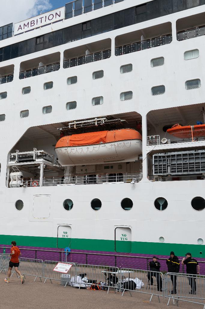 A barrier is set in front of the British cruise ship Ambition, as French authorities have ordered 1,700 passengers and crew to stay on board due to a gastrointestinal illness outbreak, in Bordeaux, southwestern France, Wednesday, May 13, 2026. (AP Photo/Caroline Blumberg)