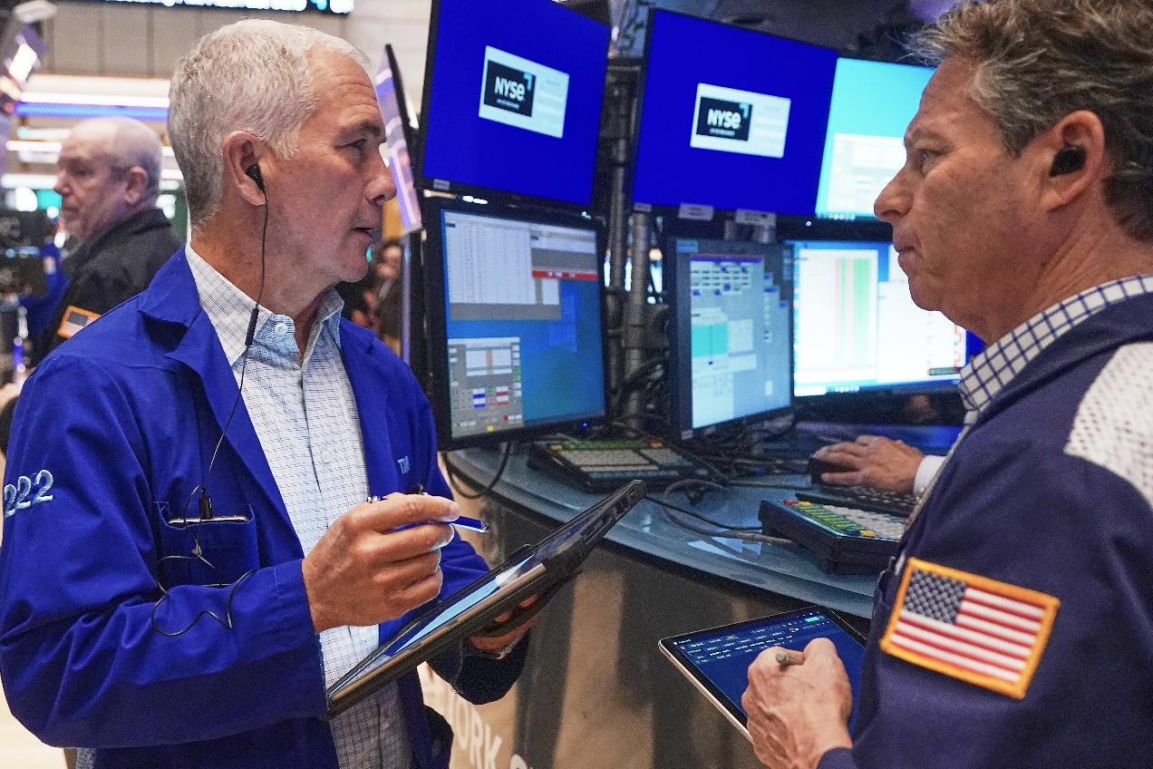 Trader Timothy Nick, left, and Robert Charmak work on the floor of the New York Stock Exchange, Friday, Feb. 20, 2026. (AP Photo/Richard Drew)