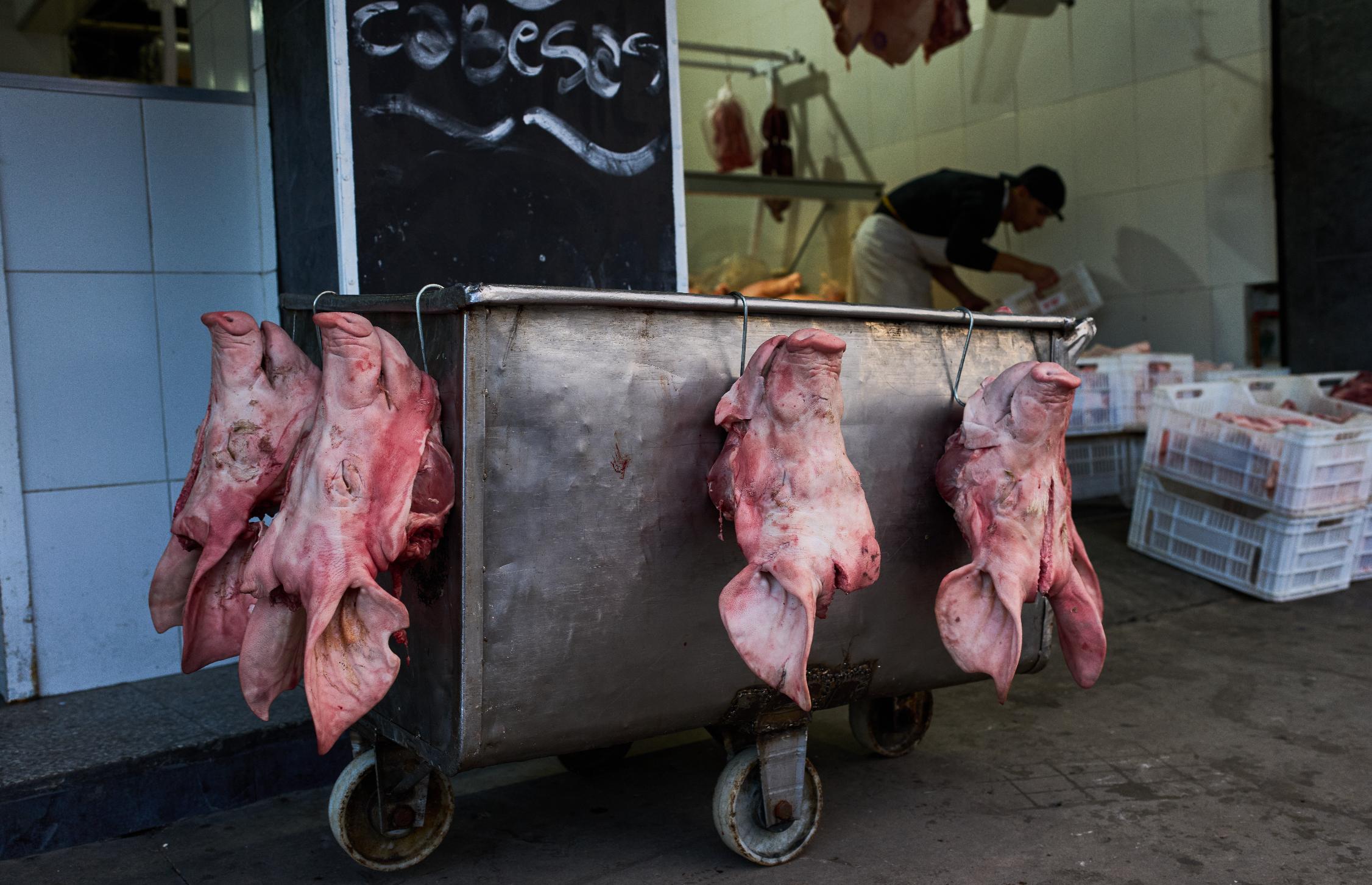 Pig heads hang outside a butcher shop for sale at the Mataderos meat market in Buenos Aires, Argentina, Thursday, May 14, 2026. (AP Photo/Rodrigo Abd)