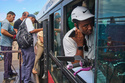 A man speaks on the phone while holding his electric bicycle in a public bus to cross the Bay Tunnel in Havana, Wednesday, April 8, 2026. (AP Photo/Ramon Espinosa)