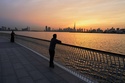 People enjoy the sunset with the view of the city skyline and Burj Khalifa, at Dubai Creek Harbour in Dubai, United Arab Emirates, Wednesday, March 11, 2026. (AP Photo/Fatima Shbair)