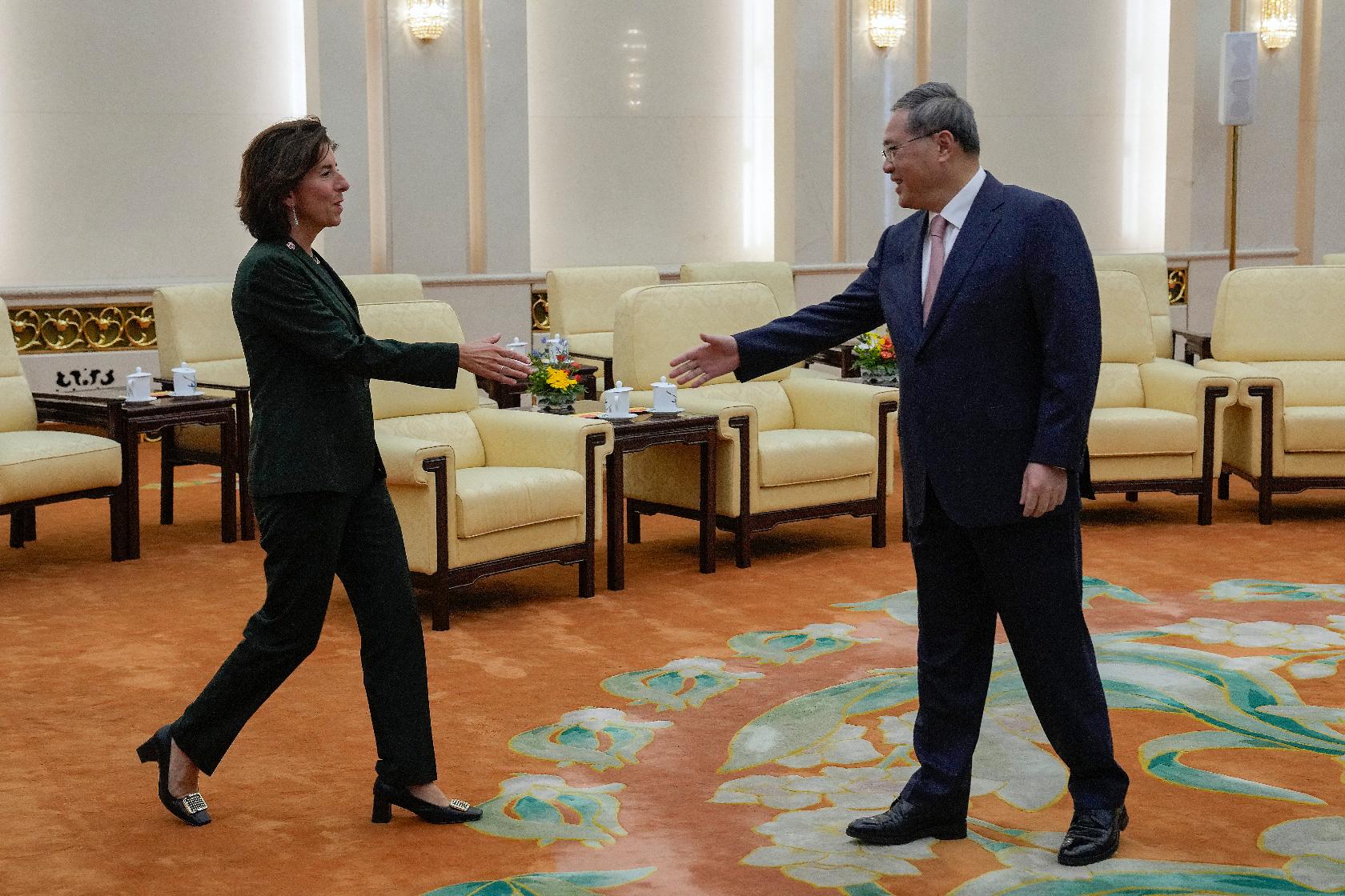 U.S. Commerce Secretary Gina Raimondo, left, greets Chinese Premier Li Qiang at the Great Hall of the People in Beijing, Tuesday, Aug. 29, 2023. (AP Photo/Andy Wong, Pool)