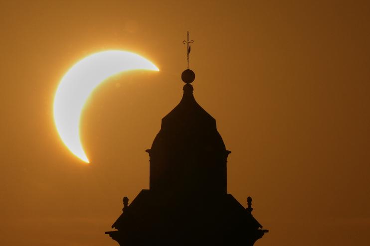 A solar eclipse is seen over a Virgin Maria church in Vidigulfo, near Pavia, northern Italy, Wednesday, Aug. 12, 2026. (AP Photo/Antonio Calanni)