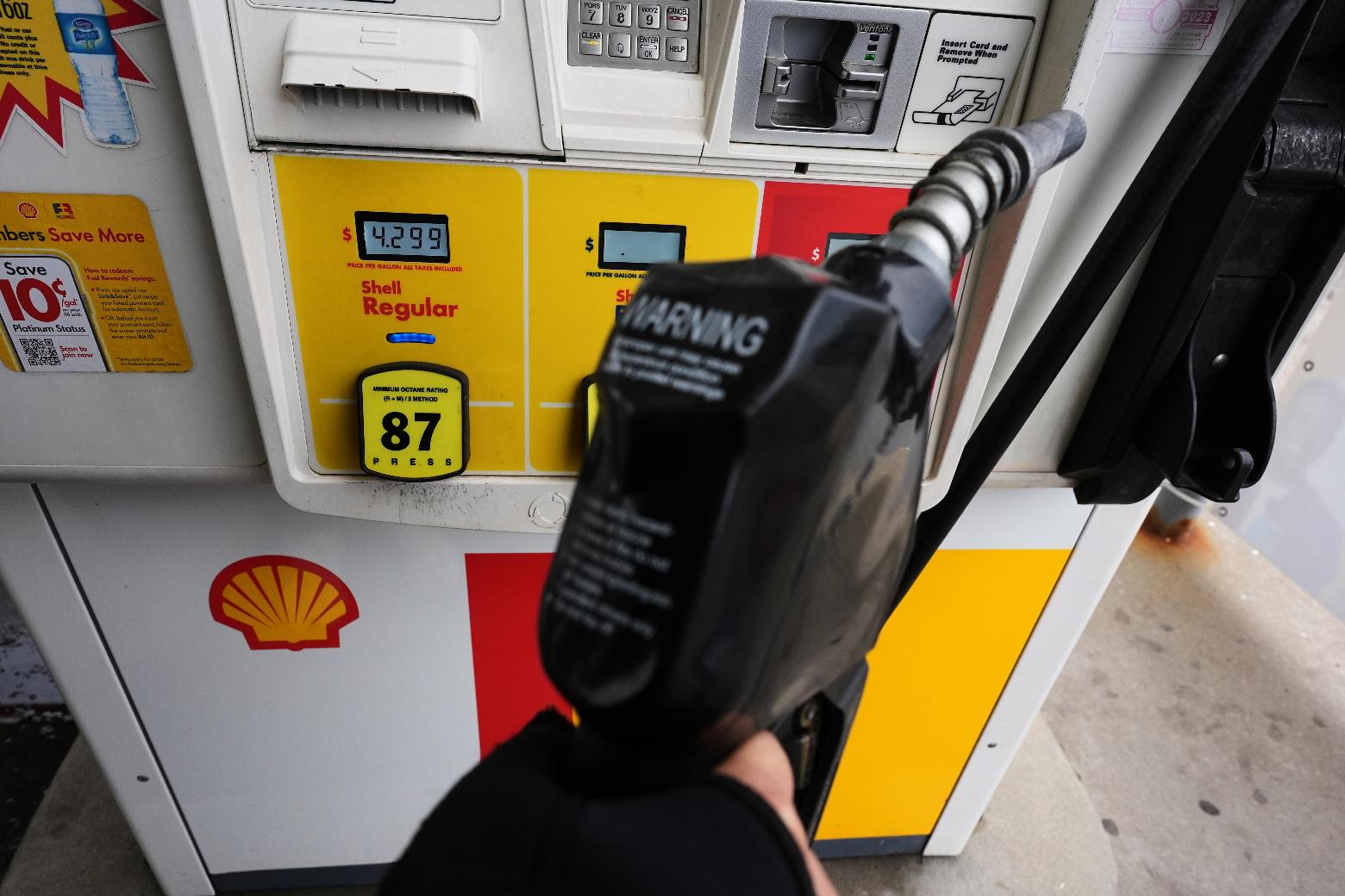 FILE - A gas price is displayed as a customer holds a fuel pump nozzle before filling up her vehicle's gas tank at a gas station, in Lincolnshire, Ill., Wednesday, April 15, 2026. (AP Photo/Nam Y. Huh, file)